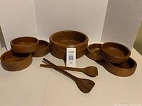 Full set of wooden salad bowls and servers displayed showing all items included in the lot.
