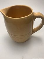 Side view of Medalta cypress basket weave jug showing spout, handle, and glaze.
