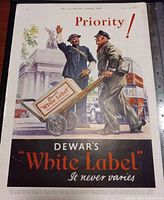 Image of original Dewar's White Label whisky advertisement from a 1942 British magazine, showing full-color illustration and text.