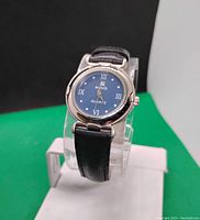 Front view of the women's quartz wristwatch showing black dial with silver-tone case and Roman numeral markers.