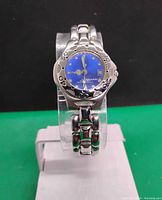 Front and face close-up showing blue dial, luminous hands and date window, polished stainless steel case and bracelet.