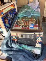 Front view of cabinet showing coin door with dual score displays and wrapped playfield