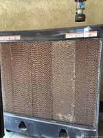 Front view of cooler showing honeycomb evaporative pads within metal frame