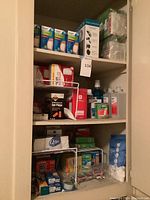 Shelves filled with assorted health and hygiene medical supplies including bandages, Q-tips, ear plugs, antiseptic bottles, gauze pads, and medical tape.