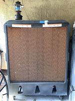 Front view showing honeycomb cooling pads, plastic housing, motor and wheel base