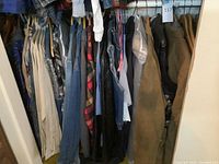 Full view of assorted men's jackets, shirts, and heavier clothing hanging on rack including denim, leather, flannel, and other items.