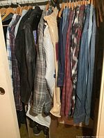 Rack of men’s large to 2XL shirts and jackets with flannels, denim shirt and shoes below