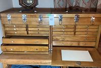 Two wooden tool chests side by side with lids closed and metal latches visible