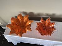 Top view of both Murano orange ruffled art glass bowls showing size and color contrast.