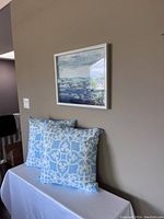 Photo showing one of the Urban Barn framed abstract artworks on a wall above blue and white patterned pillows.