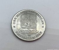 Front side of the Maui Trade Dollar coin with denomination and usage information