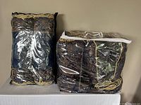 Two clear plastic storage bags holding the duvet cover and cushions folded and packed inside