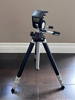 Close-up photo of Star-D Jupiter tripod head and upper legs showing brand label and adjustment elements.