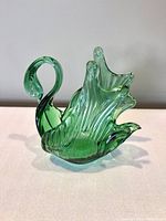 Front view of the green glass swan figurine showing the curved neck, textured wings and overall shape.