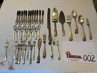 Overview of all 44 flatware pieces laid out on table