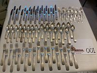 Overhead view of full 81-piece flatware set arranged by type