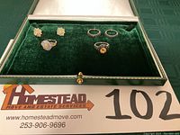 Full view of the five jewelry pieces in a green velvet box.