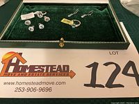 Full set of sterling silver sky blue topaz jewelry including 2 rings and 3 pairs of pierced earrings displayed in a green velvet case.