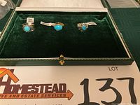Three turquoise rings on green velvet inside a box, showing overall lot composition