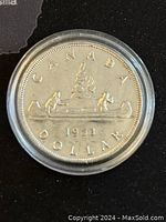 Obverse side of 1953 Canadian Silver Dollar showing two men paddling a canoe, year 1953, and inscriptions 'CANADA' and 'DOLLAR'.