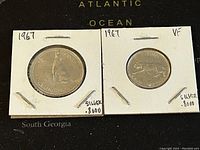 Front and reverse views of two Canadian 1967 silver coins, 50 cents and 25 cents, in holders with condition and silver content noted.