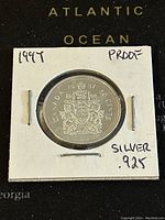 Obverse side of the 1997 Canadian 50 cent silver proof coin showing the Canadian coat of arms and inscriptions.