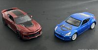 Photo of both die cast cars showing overall appearance and colors - blue Nissan 370Z and maroon Chevrolet Camaro ZL1