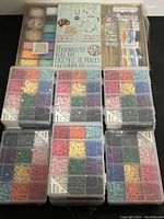 Front view of the complete bead sets, tools, and accessories included in the kit showing the unopened boxes of beads, cords, tools, and packaging.