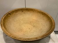 Top view showing the large interior and worn surface of the wooden dough bowl.
