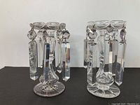 Two antique crystal candle holders with hanging prism crystals displayed side by side, showing overall appearance and condition