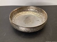 Angled front view showing the interior detailing and floral engraving pattern inside the silver bowl.