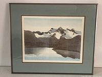 Framed watercolor artwork showing mountain landscape with lake reflection