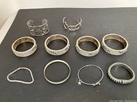 Top-down photo showing all 10 bracelets arranged flat on a black surface.