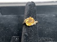 Front view of the 10KT gold ring featuring an oval citrine gemstone set with four prongs on a delicately twisted band.
