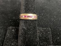 Front view of ring on black velvet stand showing ruby and diamond setting