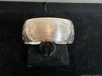 Front view of cuff showing central beaver motif and geometric border