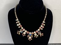 Front view of necklace on black velvet bust showing overall design and color