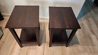 Top view of two dark wood end tables side by side showing rectangular tops and straight legs.