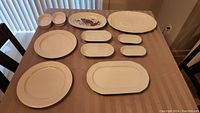 Full view of all eleven serving platters set on a table.