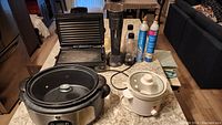 Wide view showing all items together on kitchen countertop—SodaStream, CO2 cylinders, Rival crockpot, large GE crockpot, and grill.