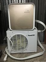 Indoor and outdoor units stacked, connection hose visible