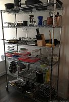 Large 6 shelf metal storage unit on wheels holding various kitchen items. Photo shows size and construction of shelving unit.