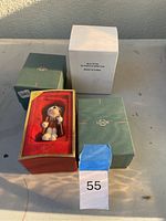 Photo of the four boxed Lenox ornaments showing their packaging and visible Santa Spin Top label.