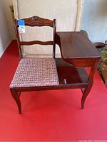 Full view of the vintage wooden telephone table with integrated upholstered chair and storage shelf.