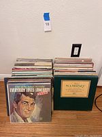 Wide view of the collection showing about 30 vinyl LPs stacked in two piles, with visible albums including Dean Martin and a green box set.