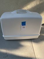 White plastic hard carrying case with handle, closed.