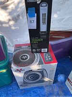 Vornado small space heater box with 15-inch tower fan box on top under shade