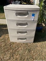 Full front view of white Sterilite plastic chest of drawers, four drawers visible, outdoor setting