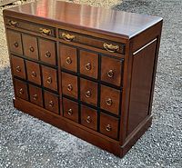 Angled front view of walnut chest showing overall structure and finish