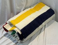 Folded blanket showing multi-color stripes on ivory background